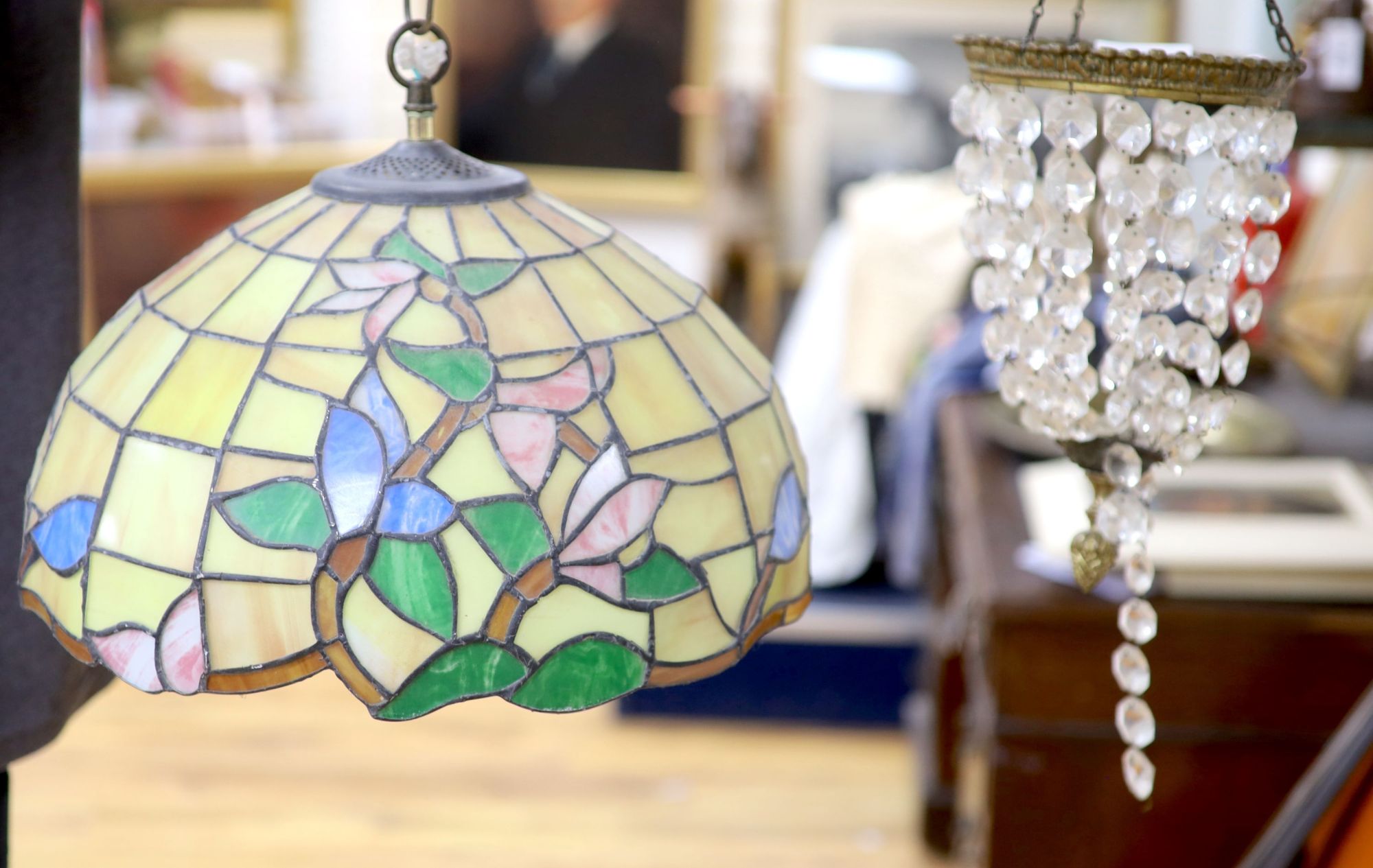 An Edwardian gilt metal and crystal drop bag chandelier and a Tiffany style lamp